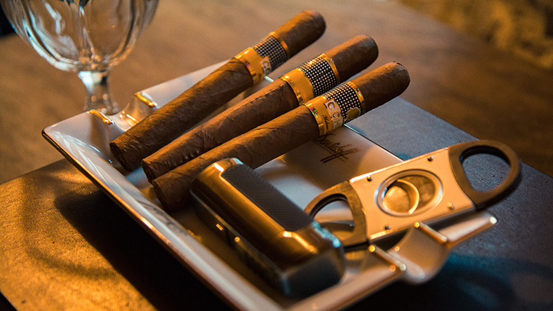Cigars and accessories in an ashtray.