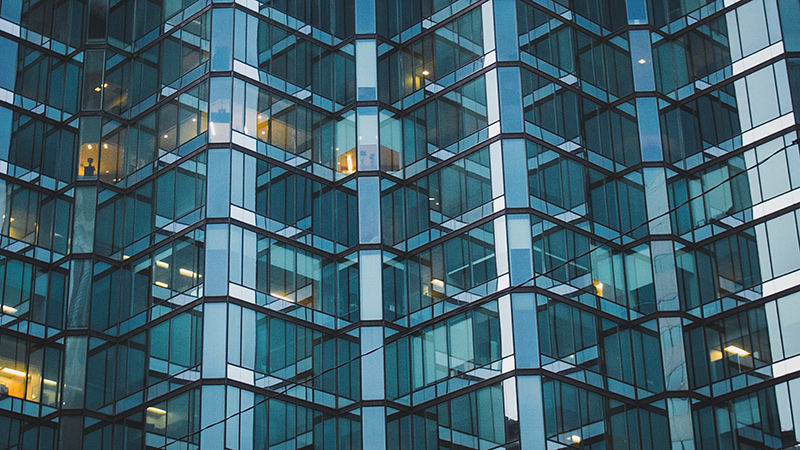 Close up of several floors of a glass office building.