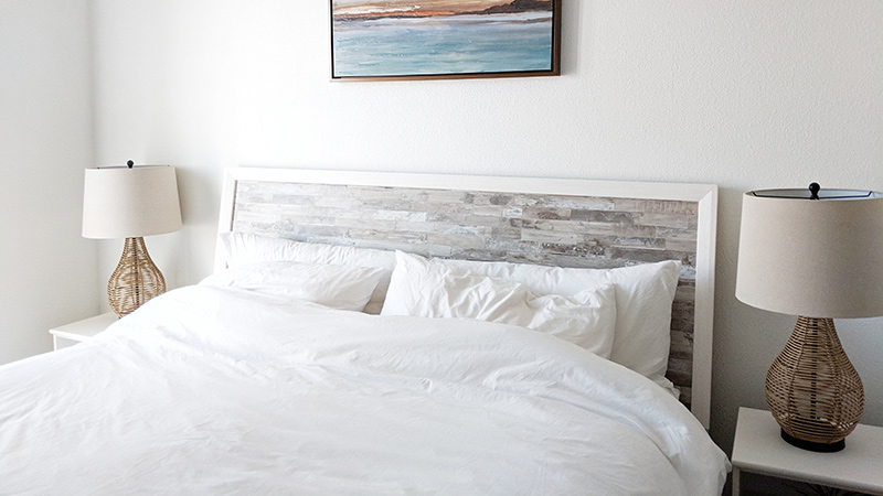 A beautifully made bed, with white linens.