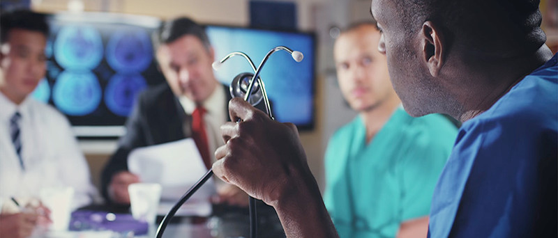 Medical professionals seated around a conference table.