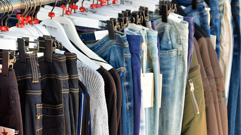 Clothes for sale hanging on a rack.