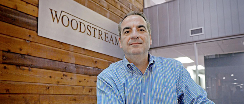 Man in front of a Woodstream banner.