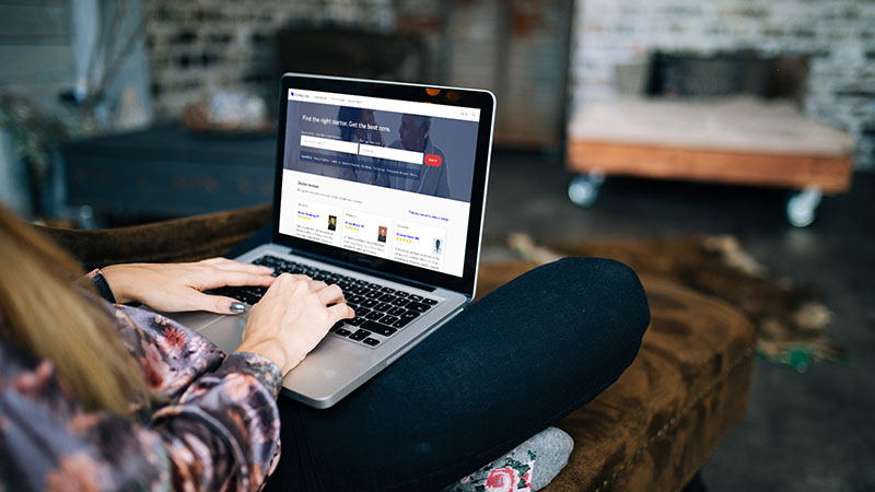 Person with laptop sitting on a couch.