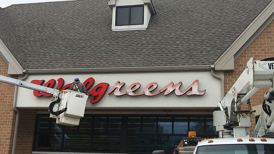 Exterior shot of a Walgreens, with a worker in a bucket making a repair.