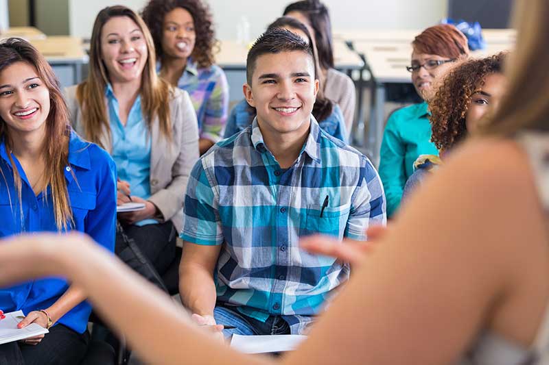 Adult students, seated in a classroom.