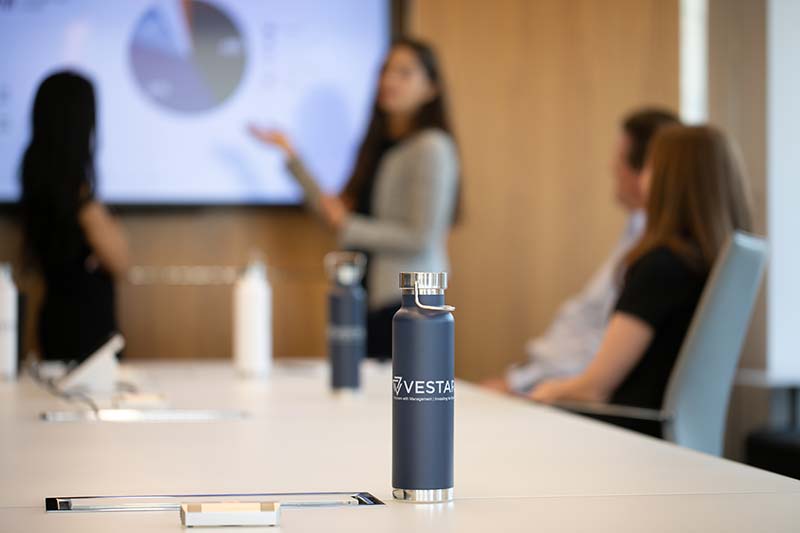 People in Vestar conference room with branded water bottle