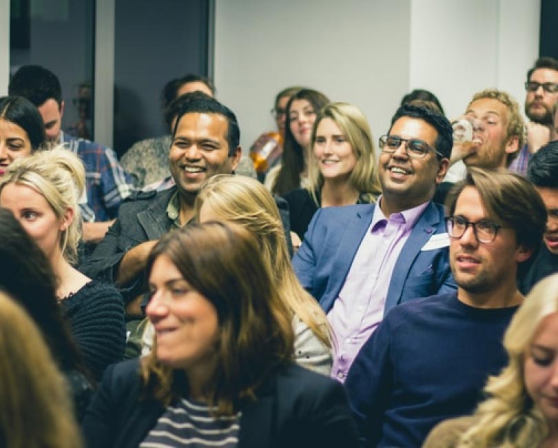 A group of young men and women listening to someone speaking